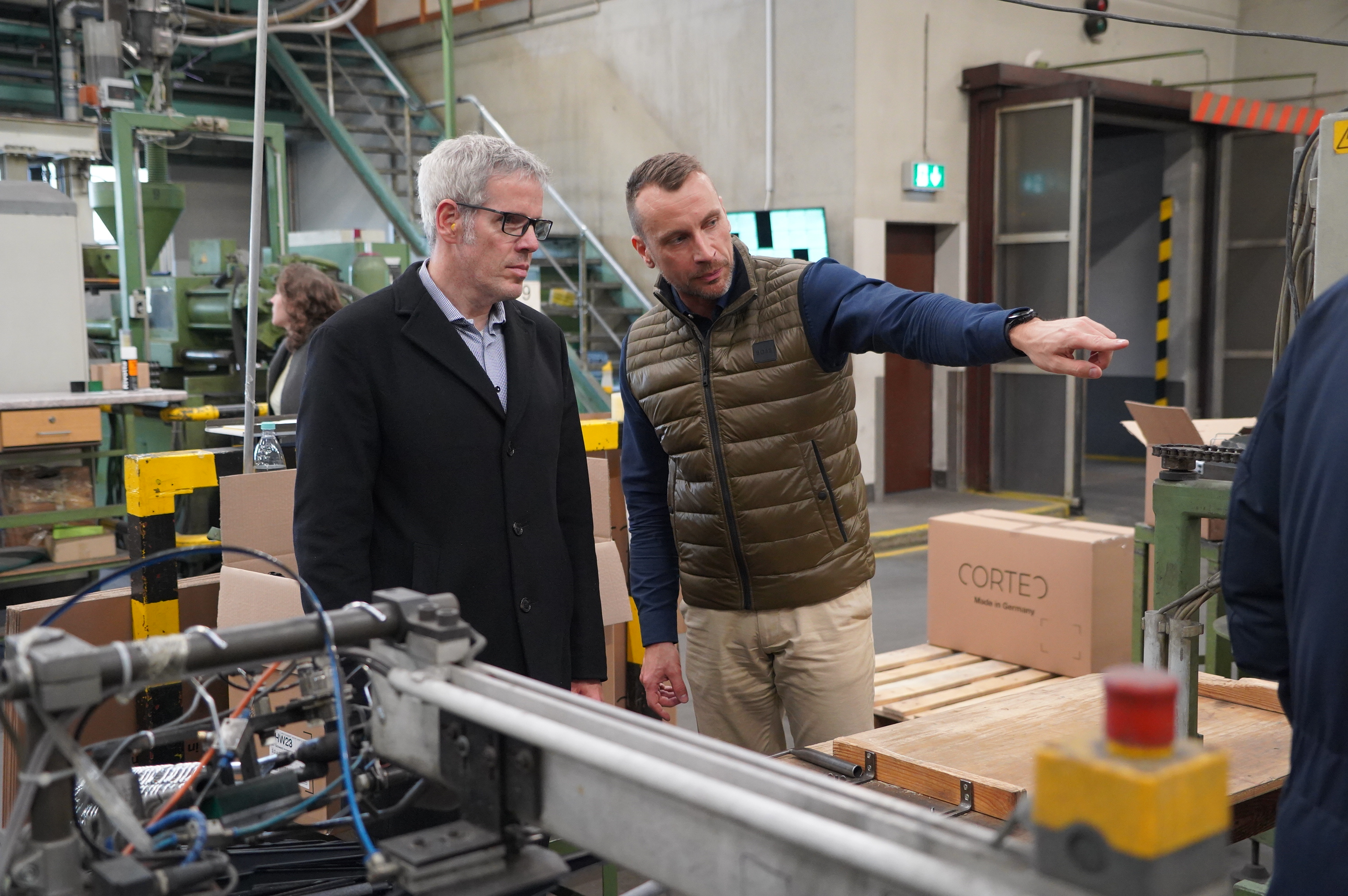 Geschäftsführer Torsten Schmitt (links) zeigt Landrat Christian Engelhardt (rechts) wie die nachhaltigen Kleiderbügel in Wahlen produziert werden. Geschäftsführer Torsten Schmitt (links) zeigt Landrat Christian Engelhardt (rechts) wie die nachhaltigen Kleiderbügel in Wahlen produziert werden.